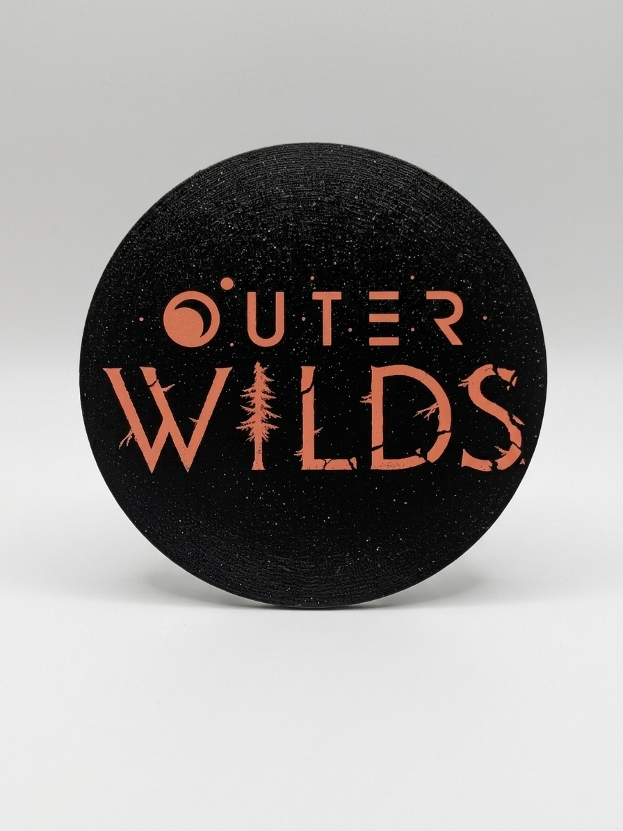 Black round coaster with 'Outer Wilds' logo on a gray background