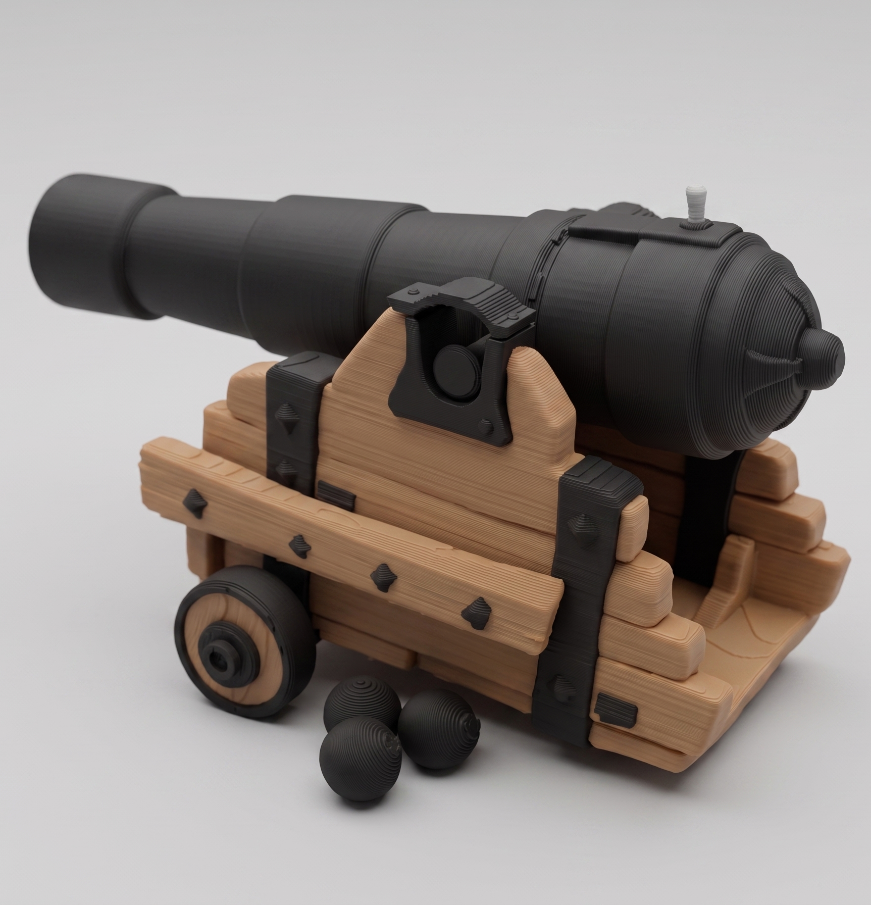 Toy cannon with wooden carriage and black barrel on a light gray background