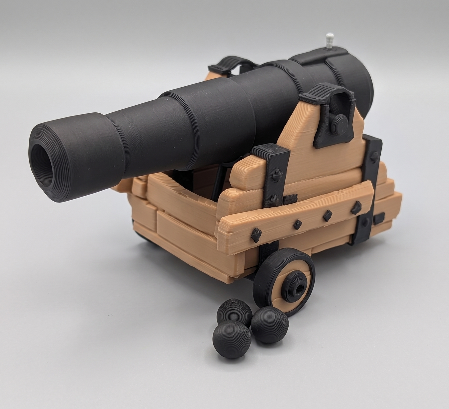 Model of a cannon on wheels with a gray background